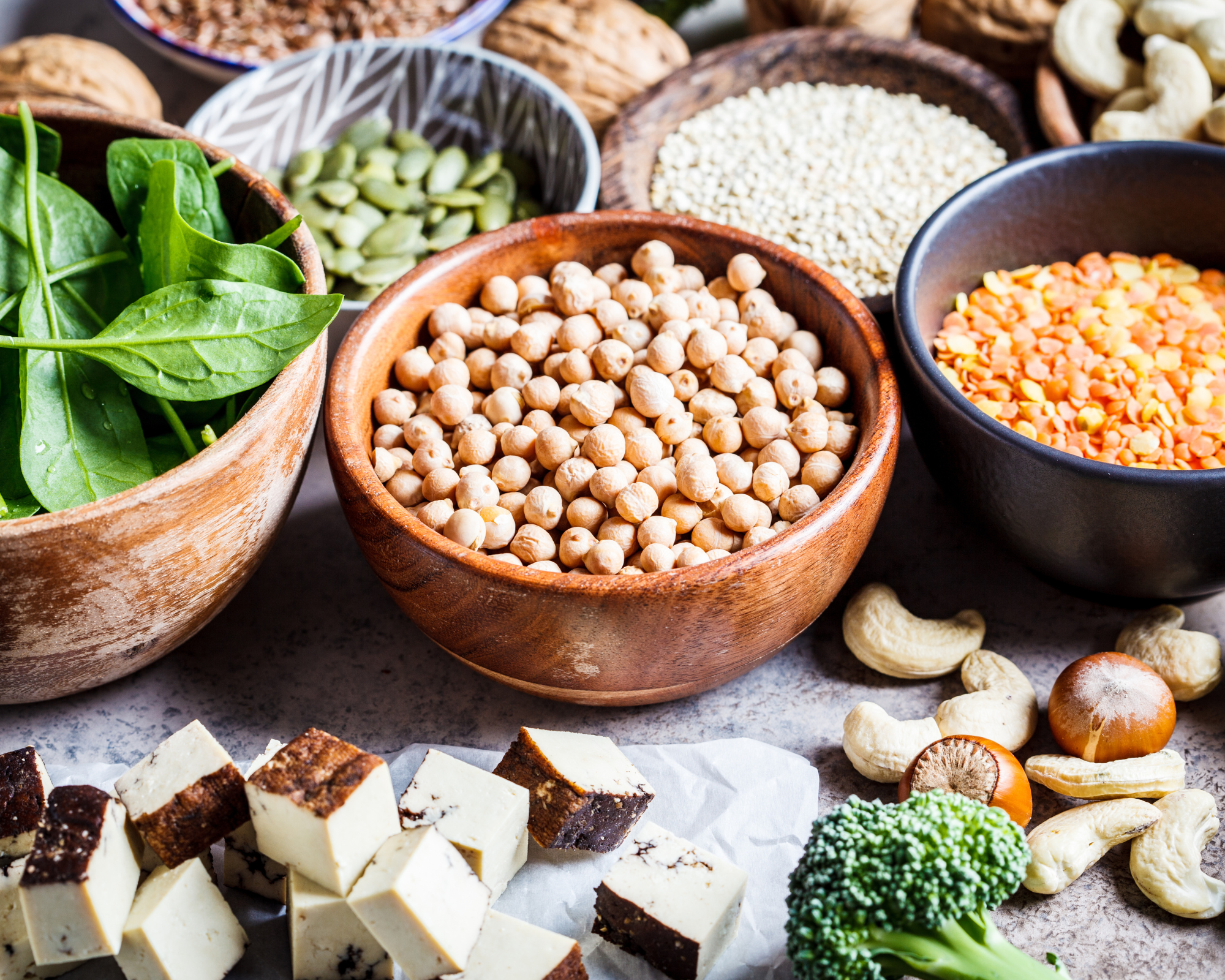 proteine in einer veganen ernährung, Bild von verschiedenen Eiweißquellen: Kichererbsen, Linsen, Erbsen, Spinat, Tofu